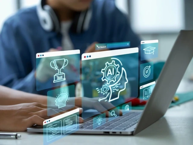 A person typing on a laptop with floating digital graphics representing artificial intelligence concepts, including icons of a human head with gears, a trophy, a graduation cap and other symbols, appearing as translucent holograms above the keyboard.